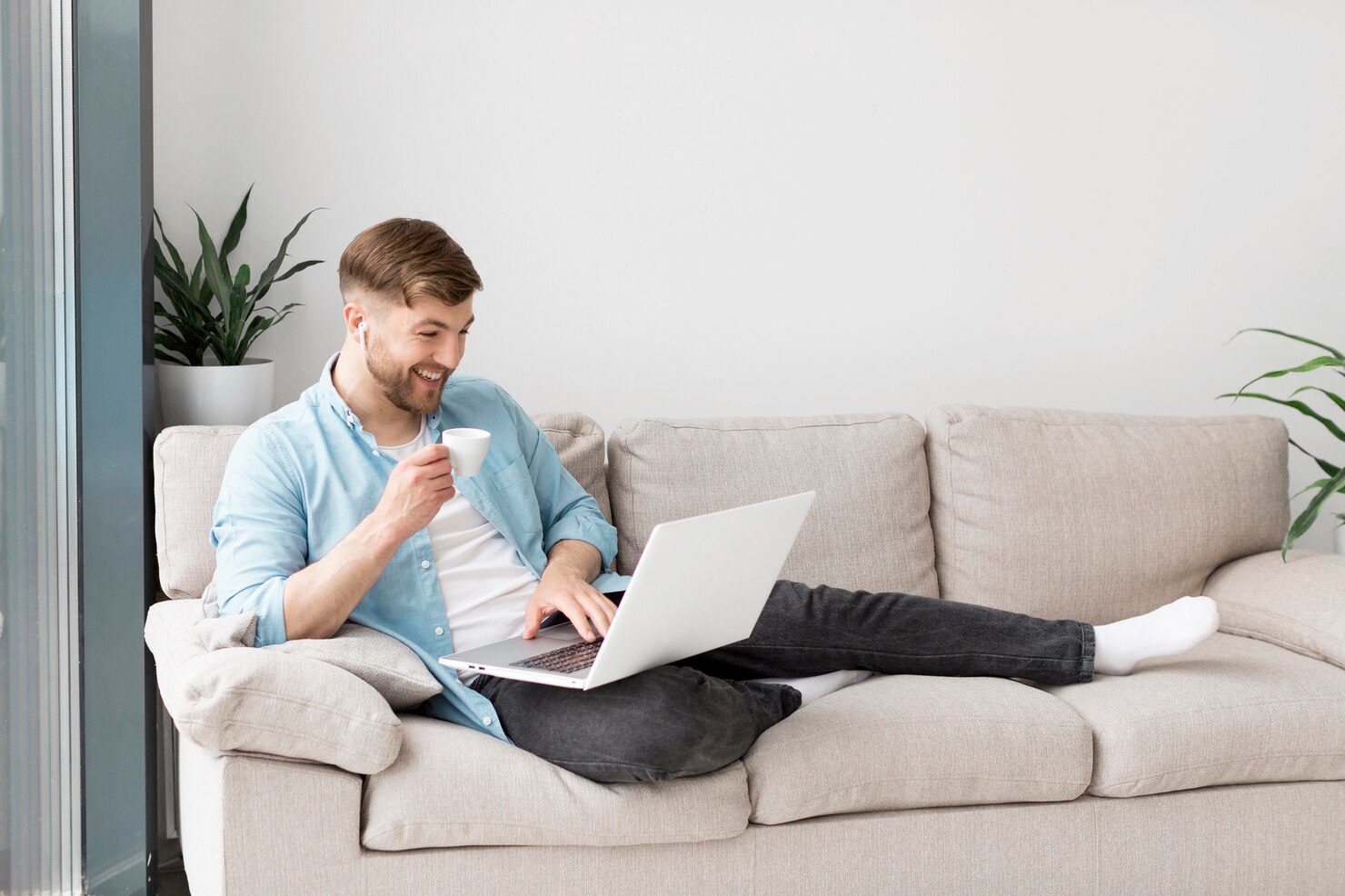 smiley-man-drinking-coffee-using-laptop_23-2148560423